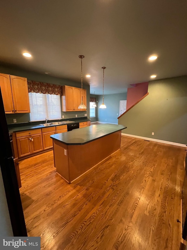 122 Lahinch Ct, Middletown, DE 19709 - kitchen with dishwasher, plenty of natural light, light wood finished floors, dark countertops, and a center island