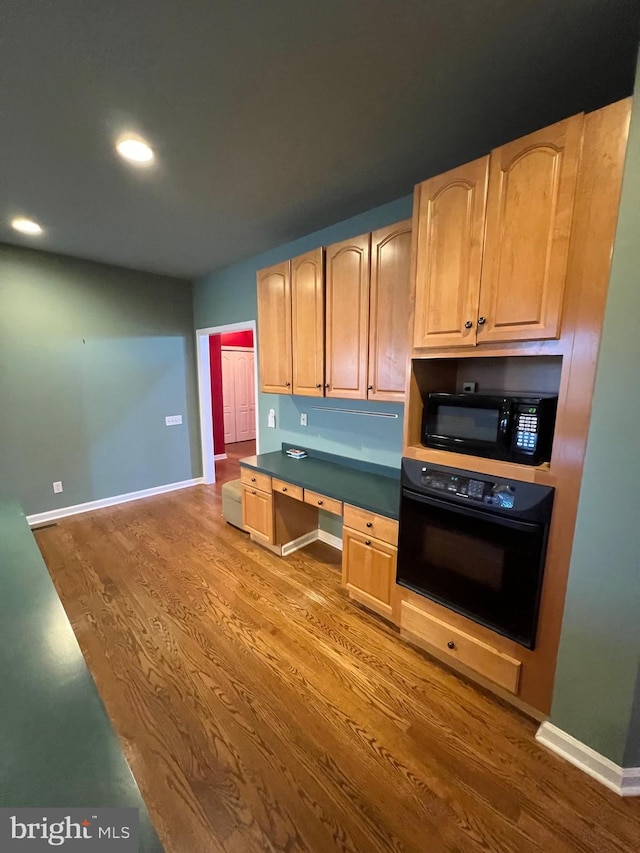 122 Lahinch Ct, Middletown, DE 19709 - kitchen featuring black appliances, wood finished floors, light brown cabinets, and built in study area