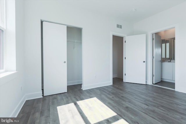 unfurnished bedroom with visible vents, a closet, baseboards, and wood finished floors