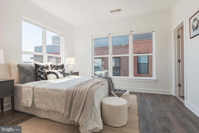 bedroom with dark wood-type flooring, visible vents, and baseboards