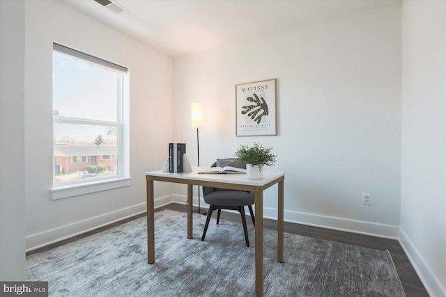 office area with dark wood-type flooring, visible vents, and baseboards
