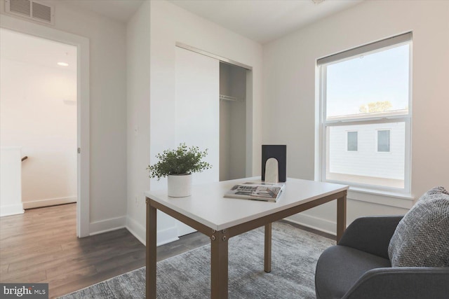 office area with visible vents, baseboards, and wood finished floors