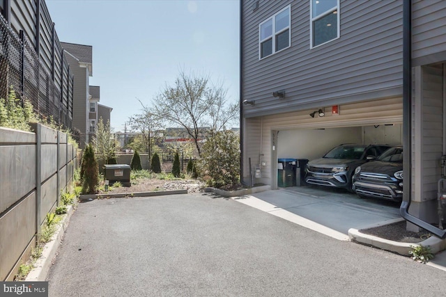 garage with driveway and fence
