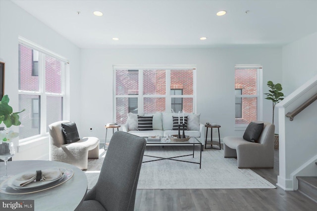 living area featuring wood finished floors, recessed lighting, baseboards, and stairs