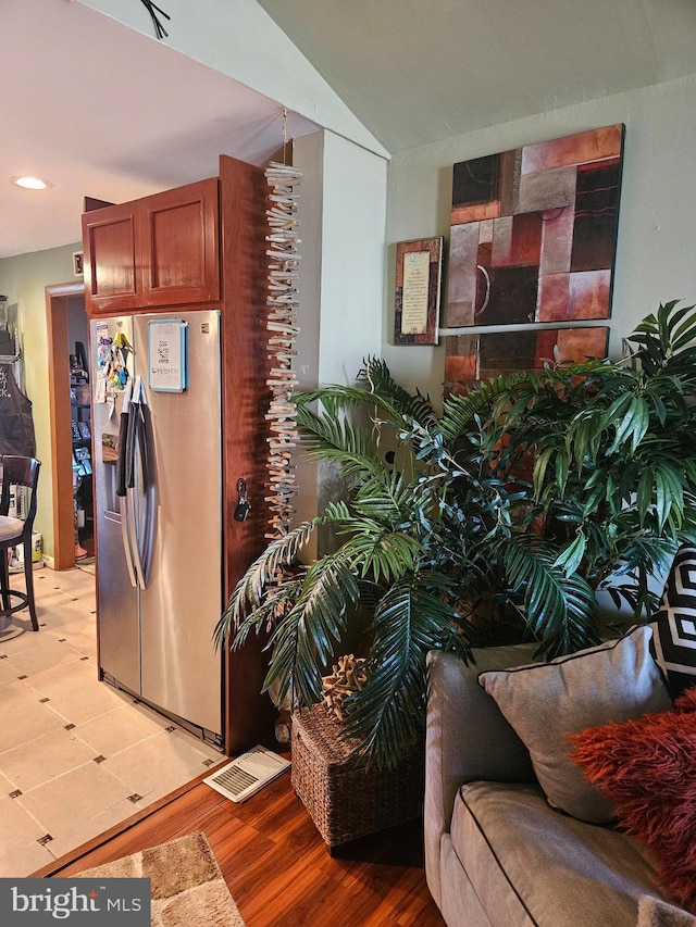 kitchen with recessed lighting, stainless steel fridge, brown cabinets, and light wood-type flooring