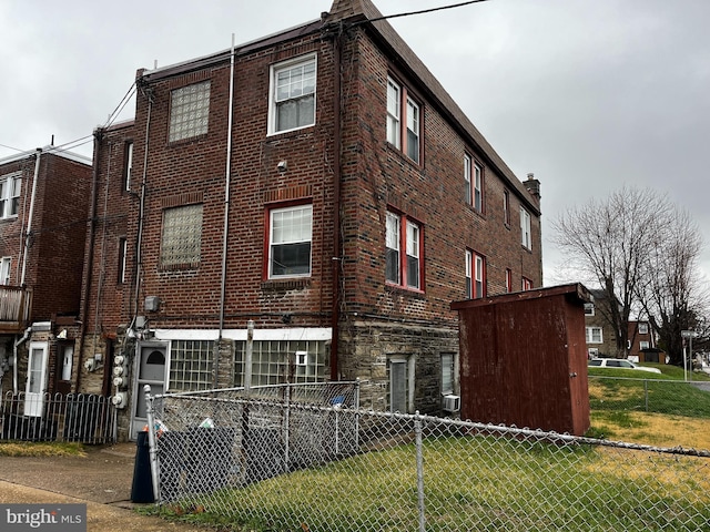 view of home's exterior featuring fence and brick siding