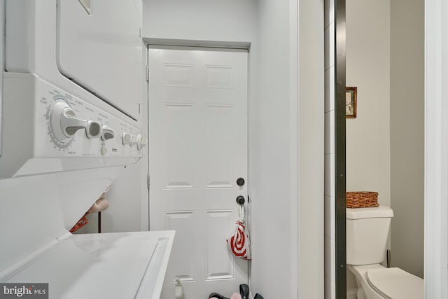clothes washing area featuring laundry area and stacked washer / dryer