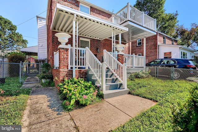 view of front of home with brick siding, fence, and a gate