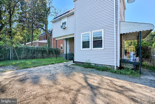 rear view of house with fence, cooling unit, central AC, and crawl space