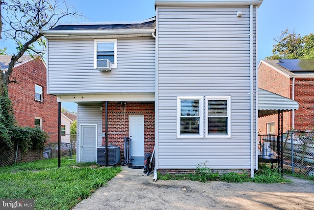rear view of property featuring central AC and fence