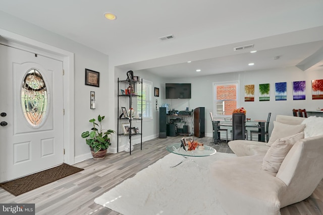 foyer featuring a healthy amount of sunlight, baseboards, wood finished floors, and visible vents