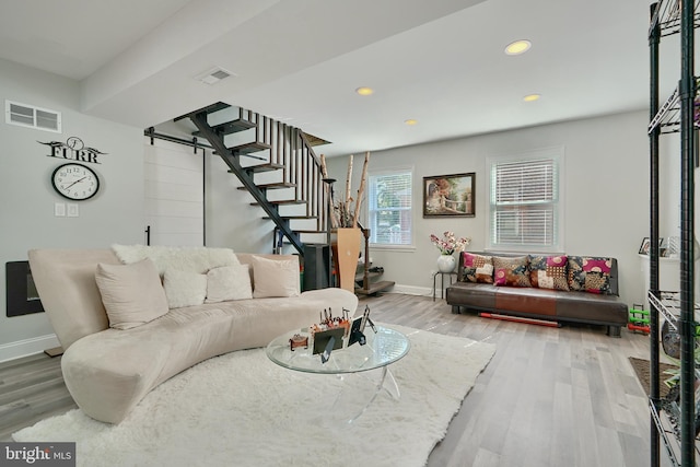 living room with visible vents, stairs, wood finished floors, baseboards, and recessed lighting