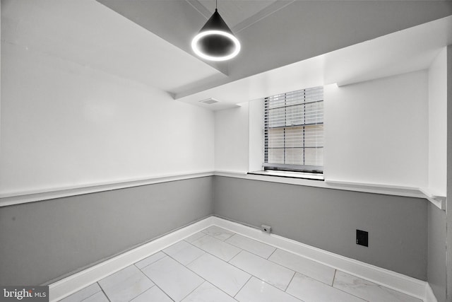 empty room featuring baseboards, marble finish floor, and visible vents