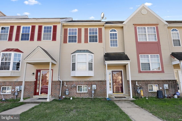 view of property with a front yard and brick siding