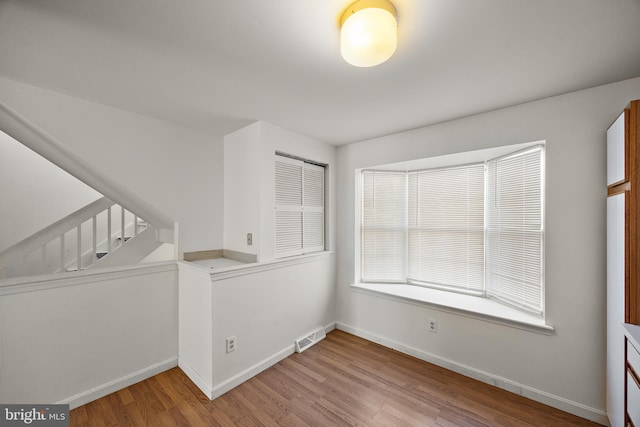 spare room with visible vents, baseboards, and light wood finished floors