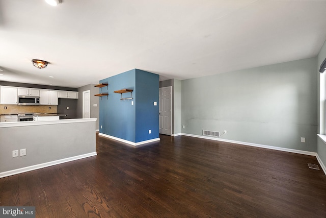 unfurnished living room featuring visible vents, dark wood finished floors, and baseboards
