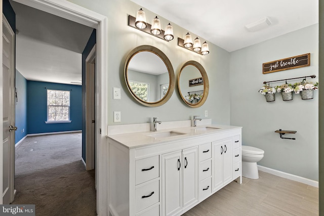 full bathroom featuring baseboards, a sink, visible vents, and double vanity