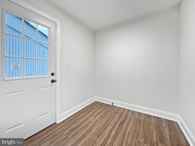 entryway featuring baseboards and dark wood-style floors