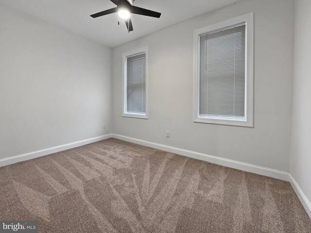 spare room featuring ceiling fan, baseboards, and carpet
