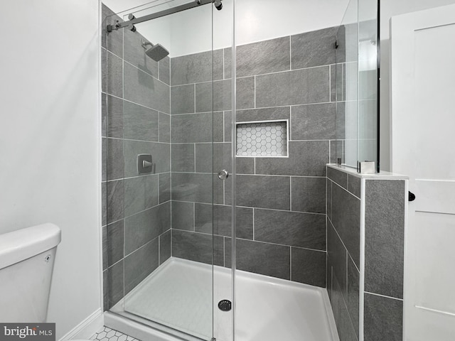 bathroom with a shower stall and toilet