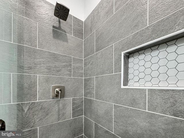 interior details with a tile shower