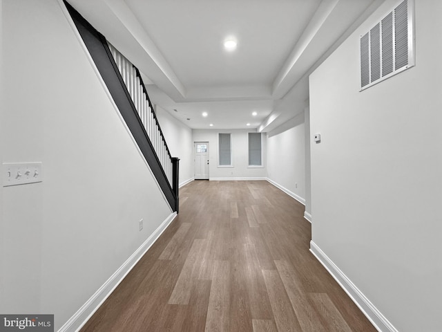 corridor featuring visible vents, baseboards, recessed lighting, stairway, and wood finished floors