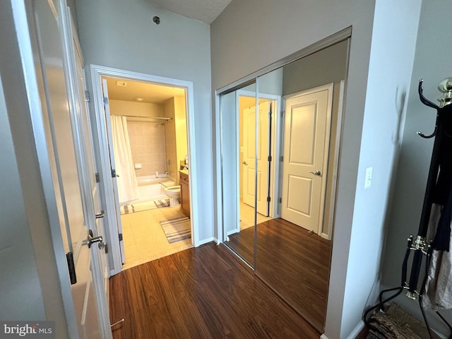 corridor with dark wood finished floors and baseboards