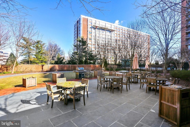 view of patio featuring an outdoor kitchen, outdoor dining space, area for grilling, and fence