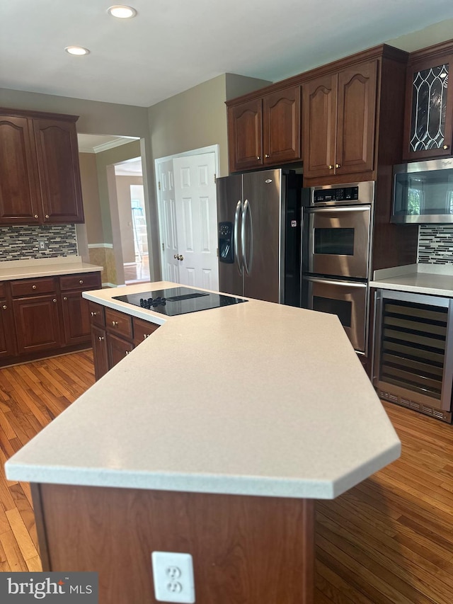 kitchen with a kitchen island, stainless steel appliances, light countertops, and wine cooler
