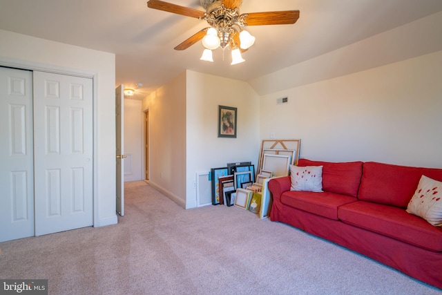 carpeted living room featuring lofted ceiling, baseboards, a ceiling fan, and visible vents