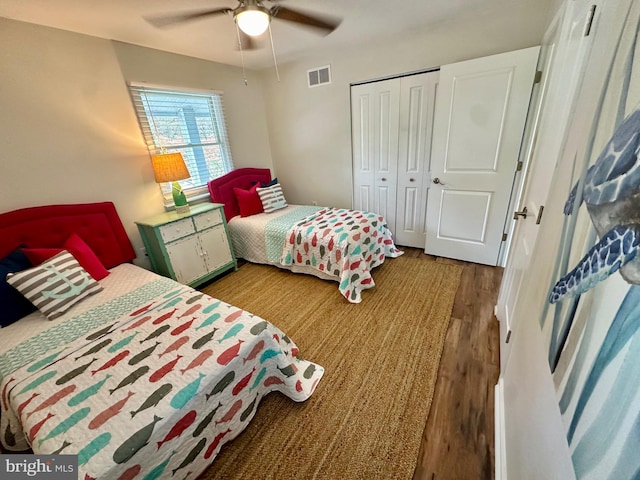 bedroom featuring visible vents, a closet, wood finished floors, and ceiling fan