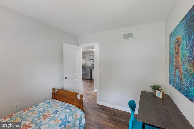 bedroom featuring wood finished floors, stainless steel fridge, baseboards, and visible vents