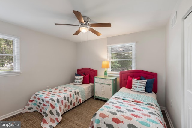 bedroom with visible vents, baseboards, ceiling fan, and wood finished floors