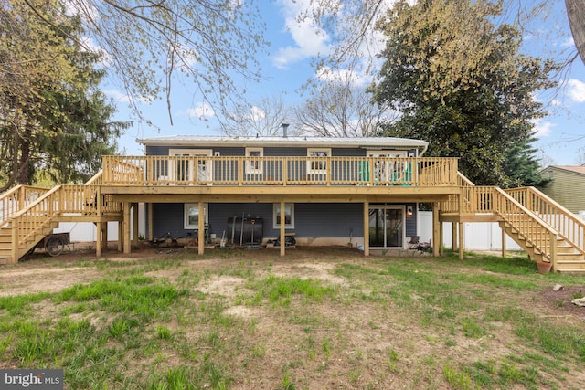 back of house with stairs, a wooden deck, and a yard