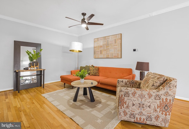 living area featuring baseboards, crown molding, a ceiling fan, and wood finished floors
