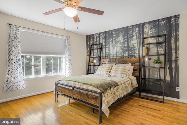 bedroom with hardwood / wood-style floors, wallpapered walls, ceiling fan, and baseboards