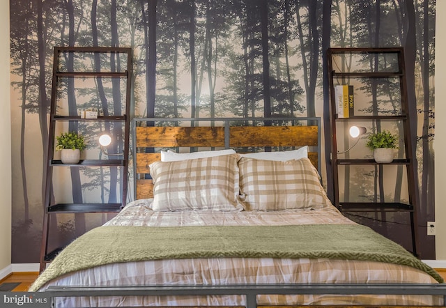 bedroom with wood finished floors and baseboards