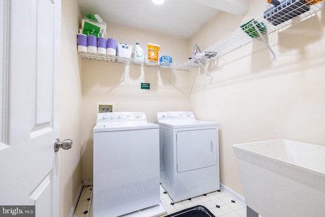 laundry room featuring baseboards, washer and clothes dryer, laundry area, and a sink