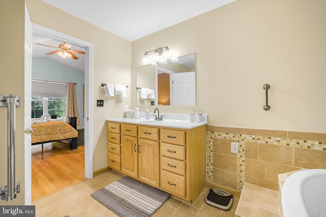 bathroom with ensuite bathroom, lofted ceiling, tile patterned flooring, ceiling fan, and vanity