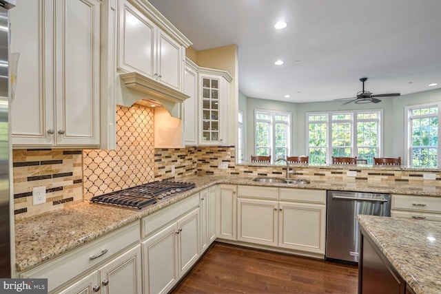 kitchen featuring a sink, backsplash, a ceiling fan, and appliances with stainless steel finishes
