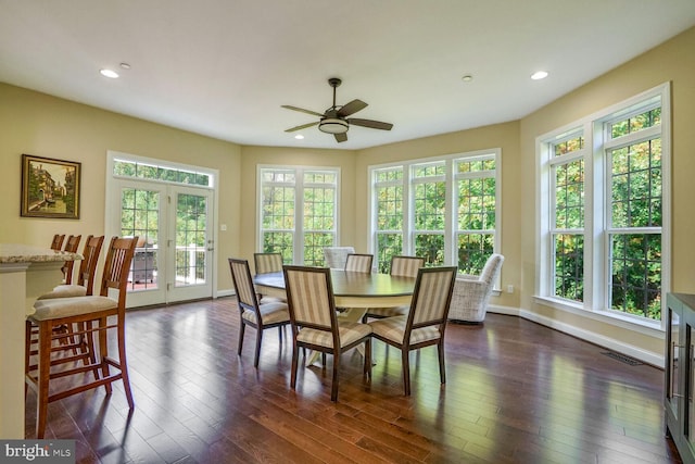 dining space featuring a healthy amount of sunlight, a ceiling fan, baseboards, and dark wood-style flooring