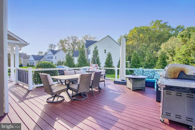 wooden deck with outdoor dining area and an outdoor fire pit