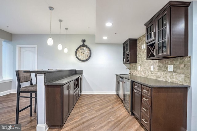 kitchen with dark countertops, dark brown cabinetry, and a kitchen breakfast bar