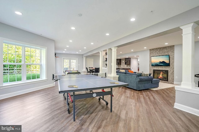 rec room with wood finished floors, recessed lighting, baseboards, and ornate columns