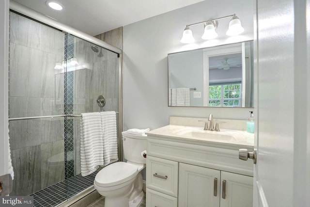 bathroom with toilet, a stall shower, and vanity