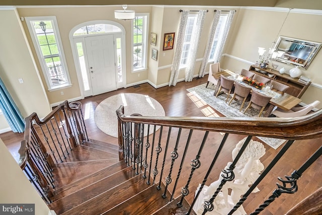 entryway featuring baseboards, wood finished floors, and stairway