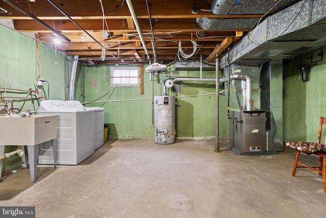 basement featuring water heater, washing machine and dryer, and heating unit