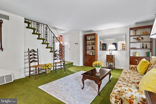 carpeted living area with stairs and baseboards