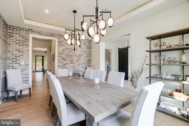 1544 Forest Villa Ln, Mclean, VA 22101 - dining space featuring a raised ceiling, a chandelier, brick wall, and light wood-type flooring