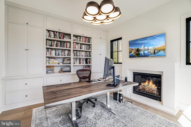 1544 Forest Villa Ln, Mclean, VA 22101 - office space featuring wood finished floors, a glass covered fireplace, built in features, and a chandelier
